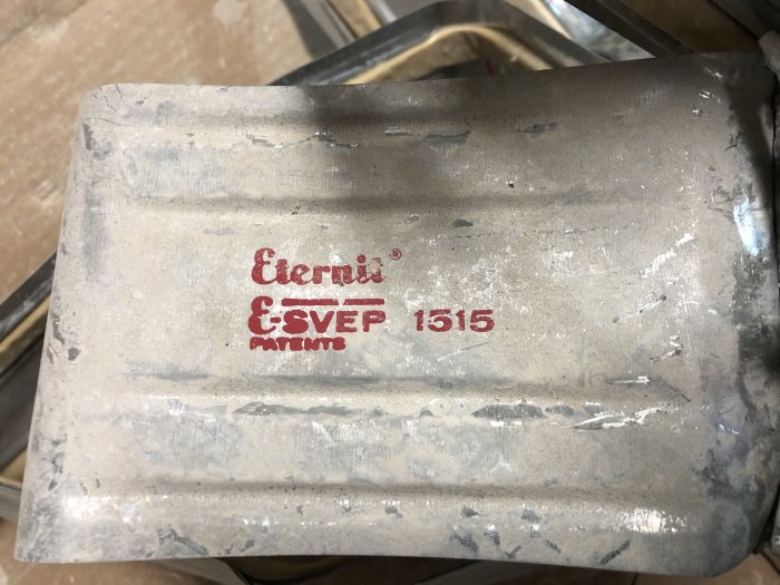 Grå eternit-cementventilation med texten "Eternit E-SVEP 1515" på ovansidan.