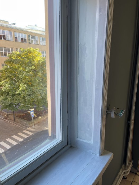 Renoveringsprocess av gammalt fönster i sekelskifteslägenhet med slipade och delvis spärrmålade ytor.