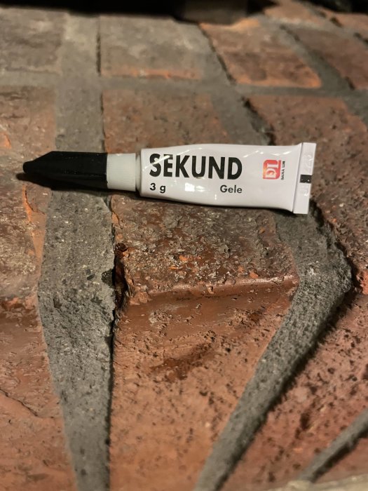 Tub med CA-baserat limmärke 'Sekund' på tegelstenar.