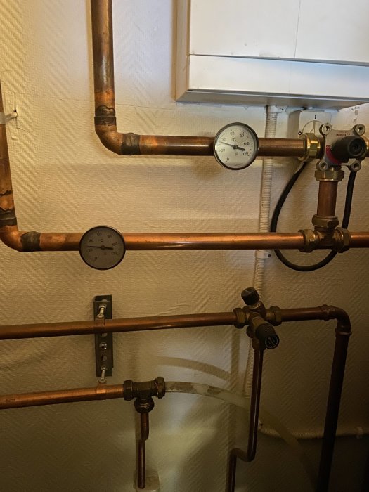 Installation med kopparledningar och mätinstrument för golvvärme, en slang kallare än övriga.