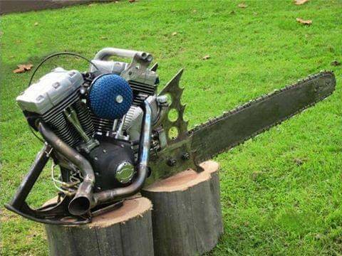 Modifierad motorsåg med stor motor monterad på en trästubbe på en gräsmatta.