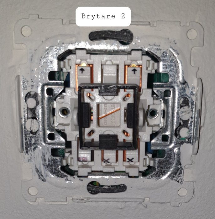 Öppen elektrisk väggbrytare utan kåpa med synliga anslutningar och märkning "Brytare 2".