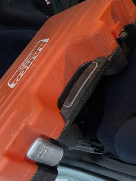 Orange förvaringsväska för verktyg med synligt skadat lås, logotyp på locket.