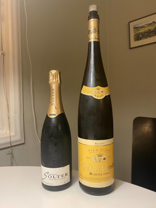 Två vinflaskor på ett bord, en mindre sekt och en magnum riesling.