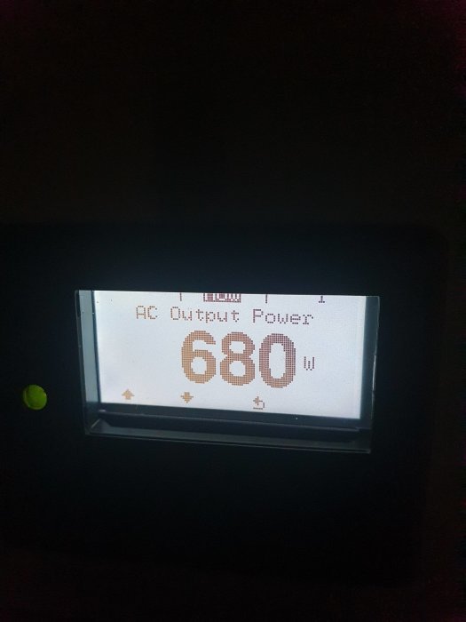 Display visar "AC Output Power 680W" på energiproduktionsmonitor i mörkt rum.