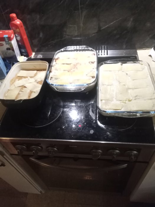 Tre formar med hemgjord lasagne på en spishäll, redo att ätas.
