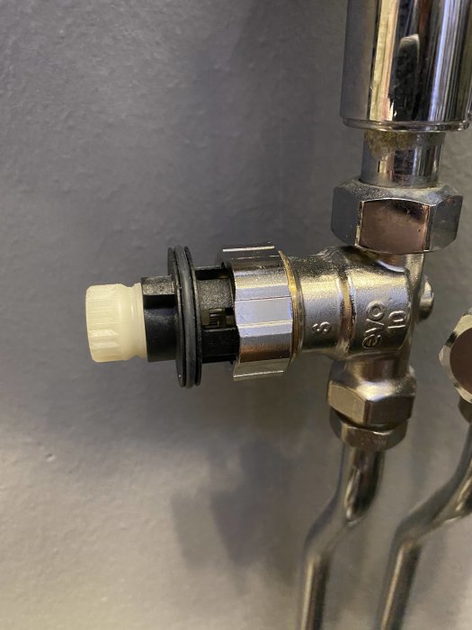 Termostat med vit plastkona som inte når ned för att stänga vattenflödet helt.