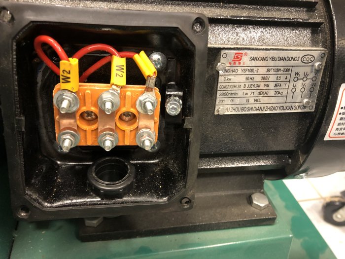Kontaktklämmor och märkskylt på en elektromotor till spånsug, med specifikationer och anslutningsdetaljer.