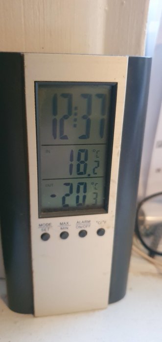 Digital termometer visar inomhus- och utomhustemperatur samt tiden 12:37.