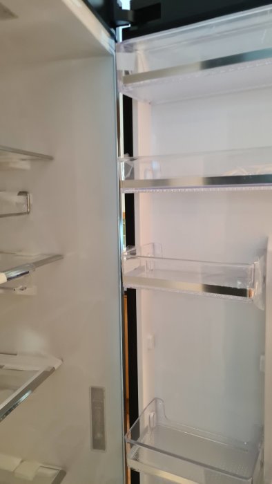 Öppet nytt Samsung kylskåp med okänd substans vid sidan som ser ut att kunna torkas bort.