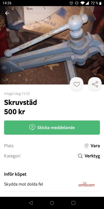 Använd skruvstäd i blå färg med synlig korrosion, placerad på ett stökigt arbetsområde.