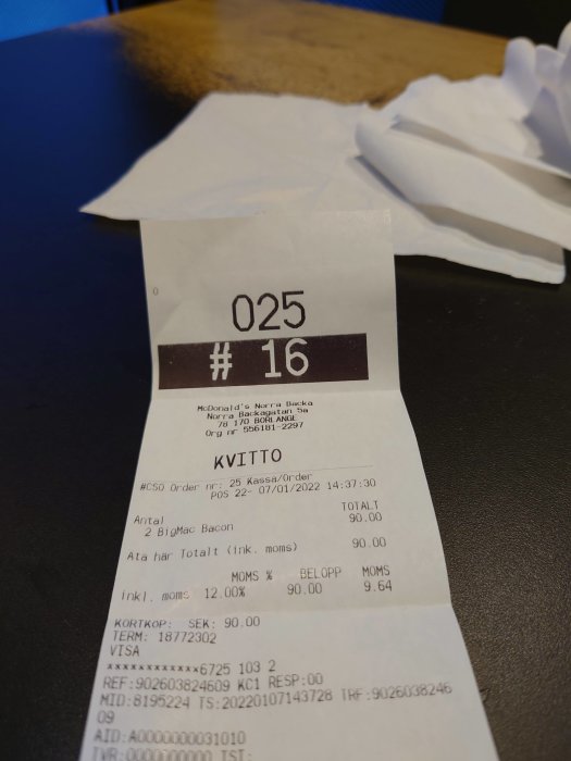 Kvitto från McDonald's med beställning av 2 BigMac Bacon för totalt 90 SEK på en mörk bordsskiva.