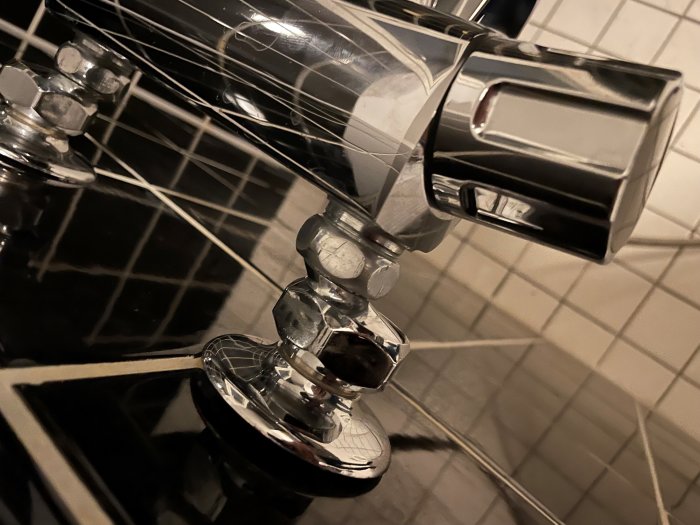 Kromad badkarsblandare med okända gängor på rör, installerad ovanför ett kaklat badkar.