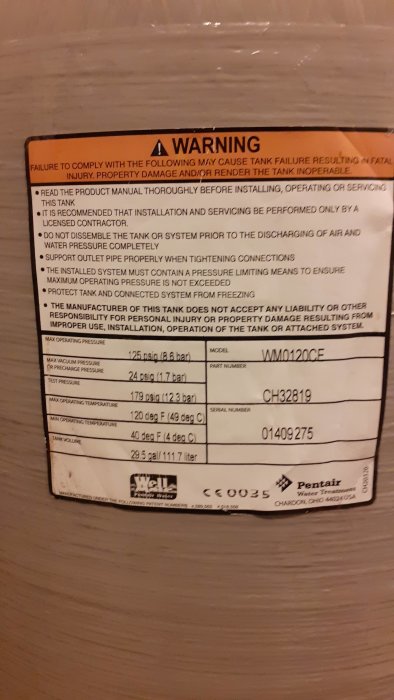 Etikett på en Wellmate hydropress med varningar och trycksinställningar.