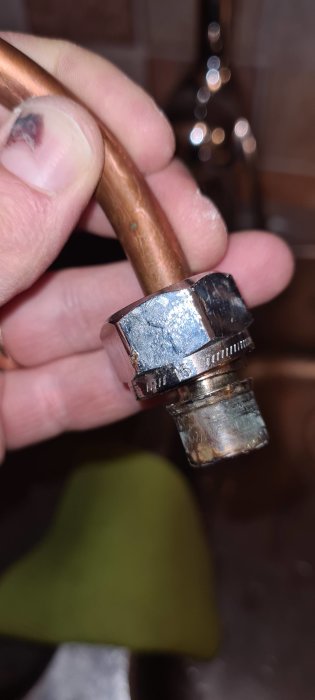 Närbild på hand som håller en vattenanslutning märkt med '15', indikerar grövre dimension.