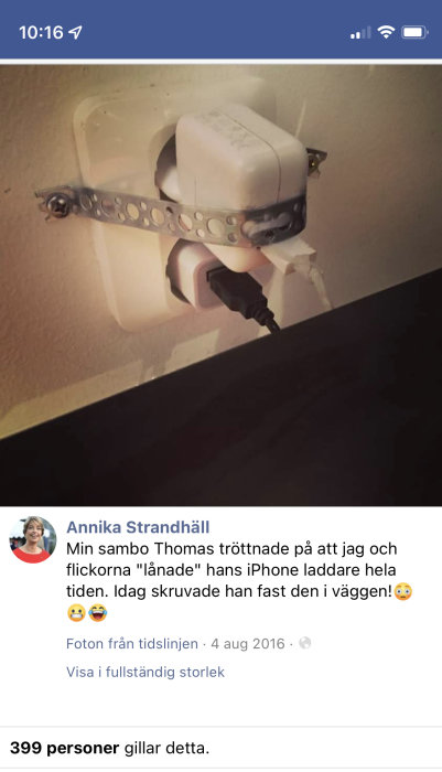 En iPhone-laddare fastskruvad på en vägg med en metallrem runt.