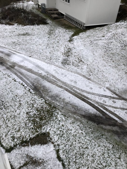 Spår i snö visar värmeeffekten där en begraven vattenslang med värmekabel går.