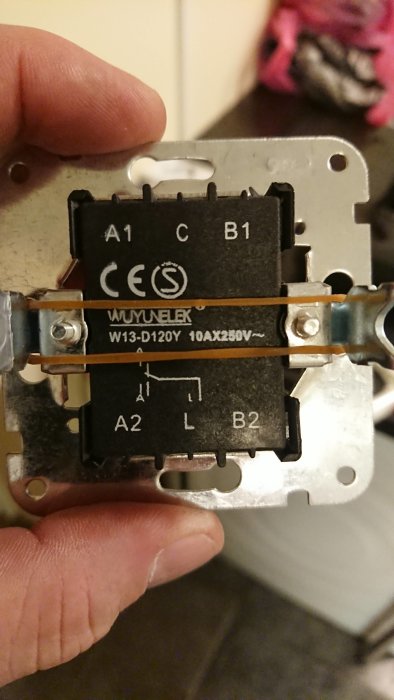 Närbild av en öppen strömbrytare med kopplingsterminaler märkta C, B1, B2, A1, A2 och L.