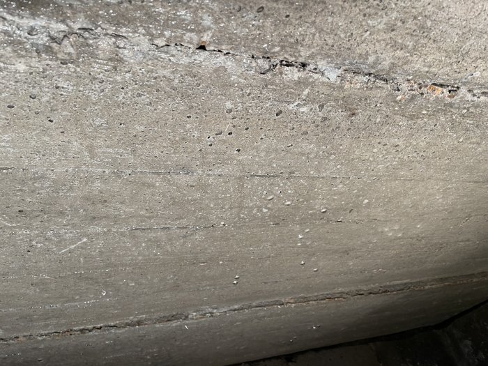Kondens med vattendroppar på en betongvägg i krypgrund nära ventilation.