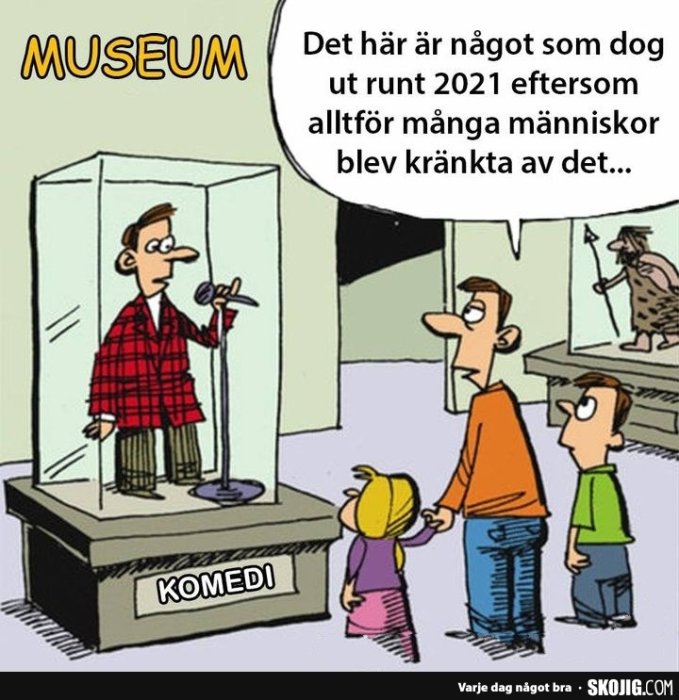 Tecknad bild av personer i ett museum som tittar på en utställning märkt "KOMEDI", med en karikatyr av en stand-up komiker.