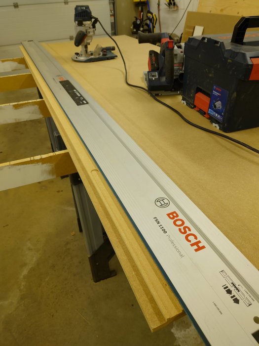 MDF-skiva med fräst kant för trappinklädnad på arbetsbänk med mätverktyg och elverktyg.