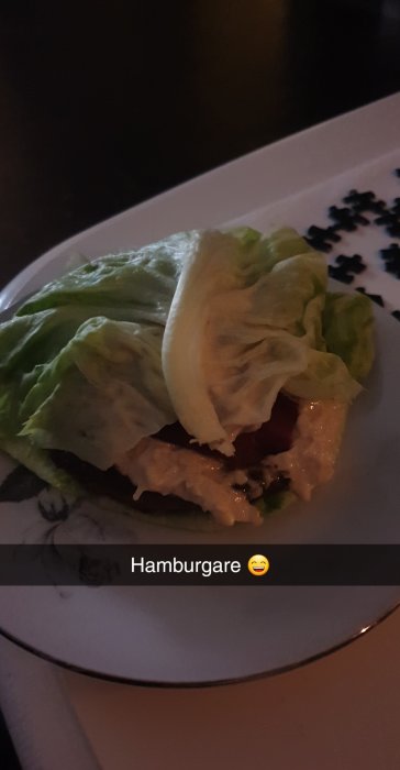 Högrevsburgare serverad mellan salladsblad med majonnäs, parmesan, jalapeño, cheddar och stekfläsk.