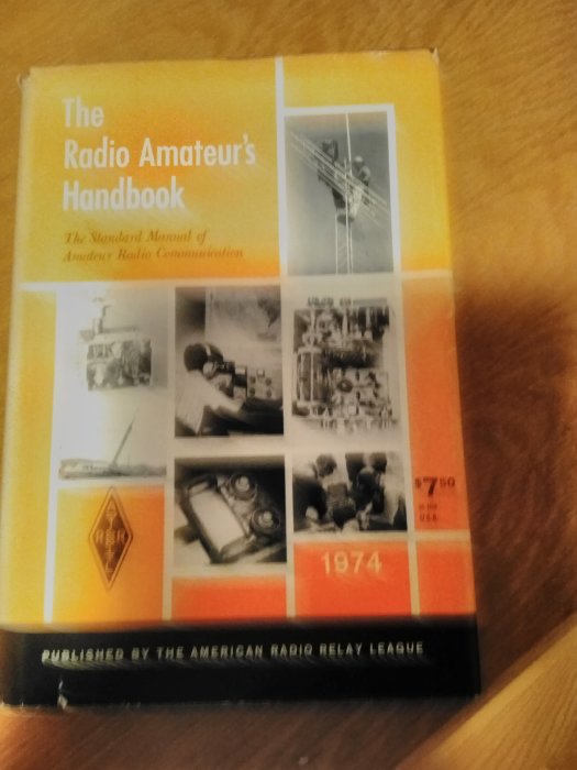 Tjock handbok med titeln "The Radio Amateur's Handbook" från 1974 med bilder på radioutrustning på omslaget.