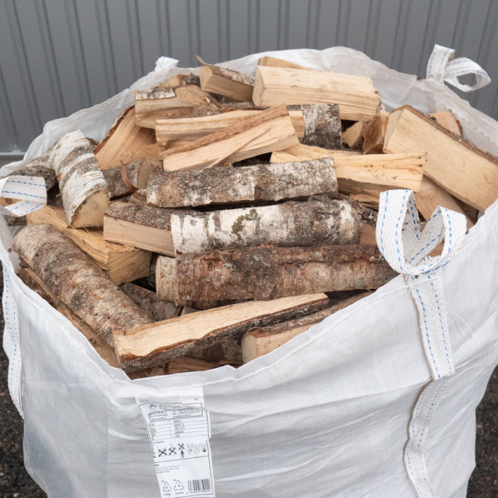 Storsäck fylld med blandad ved avsedd för braskamin eller öppenspis.