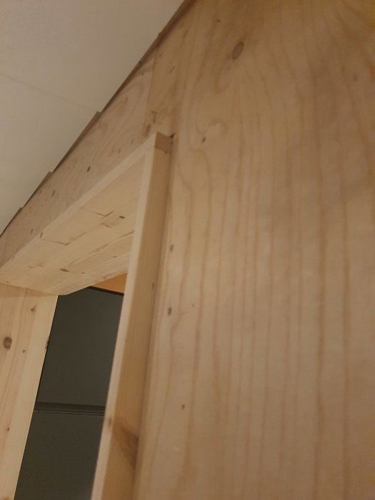 Närbild på väggpanelens hörn där träelementen är noggrant ihopfogade utan synligt ändträ.