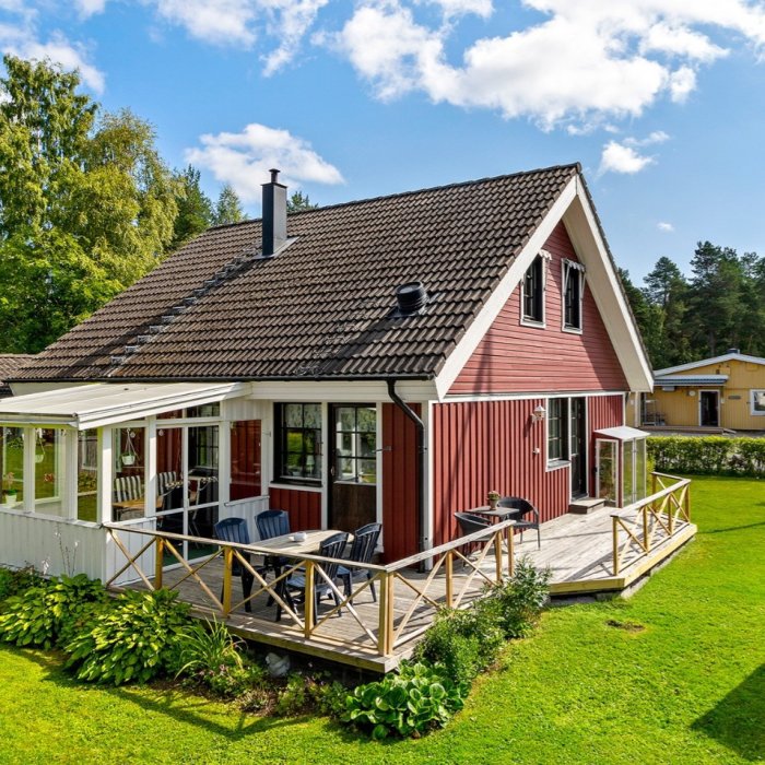 Tvåvåningshus från -83 med rött tegeltak och bruna fönster som ska målas om till vitt.