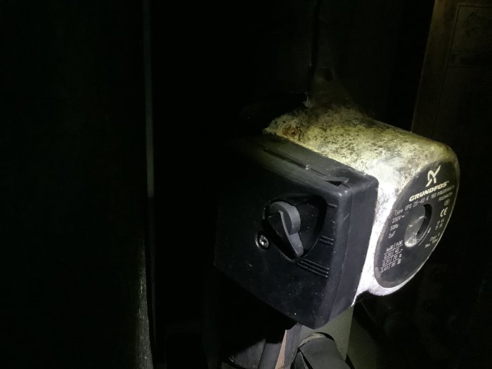 En dammig och smutsig cirkulationspump av märket Grundfos med en vred inställd på läge 3.
