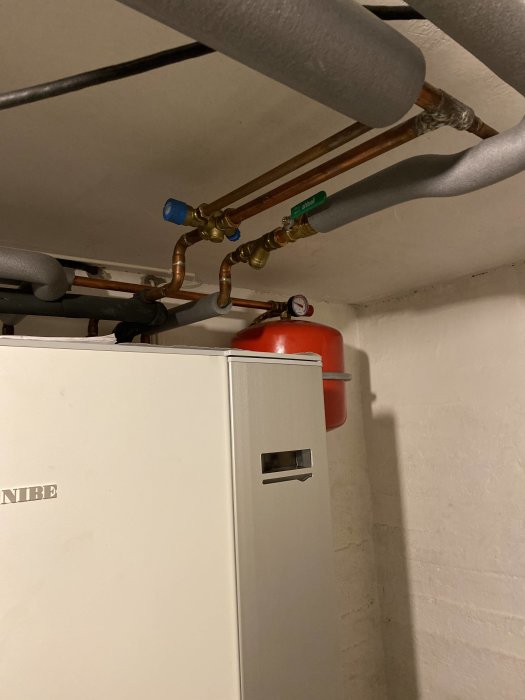 Pelletspanna med olika rör och kranar installerade ovanför, ingen varmvattengenerator synlig.