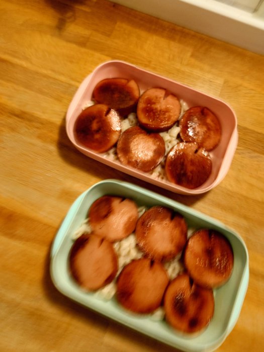 Två matlådor med stuvade makaroner och stekta falukorvsskivor.