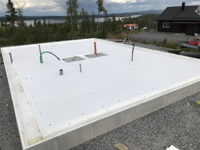 Isolerrad grundkonstruktion med cellplast och armeringsnät före betonggjutning.