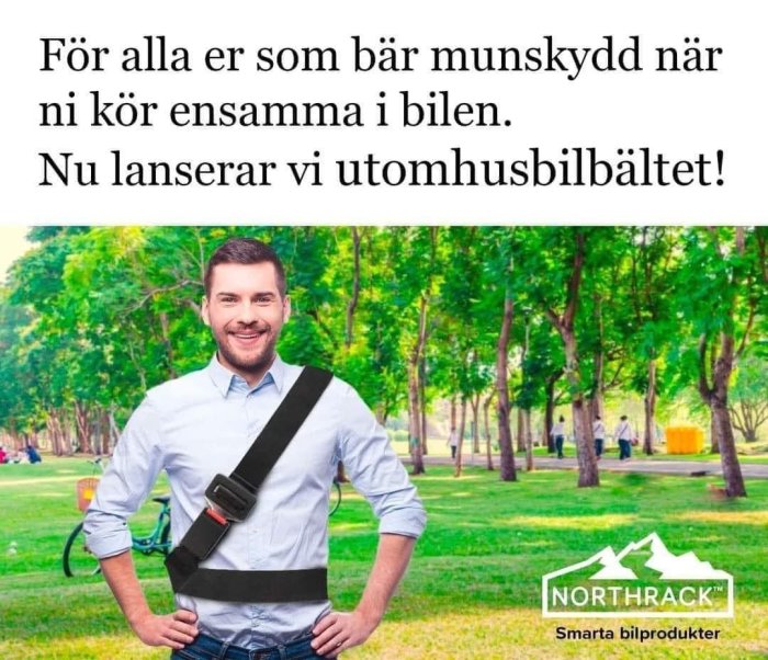 Leende man i skjorta med ett svart bilsäkerhetsbälte står framför en park, reklam för NORTHTRACK utomhusbilsbälte.