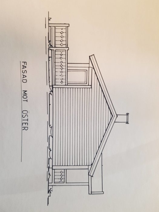 Fasadritning av en avlång byggnad med sadeltak och flera fönster mot öster.