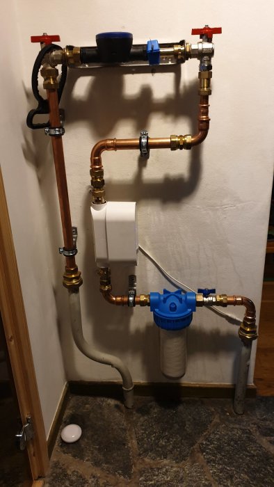 Installation av rörsystem med Grohe-ventiler och vattenfilter monterat på vägg.