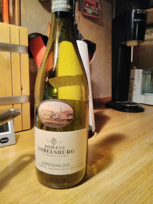 Flaska av Gobelsburg Grüner Veltliner vin på ett köksbord.