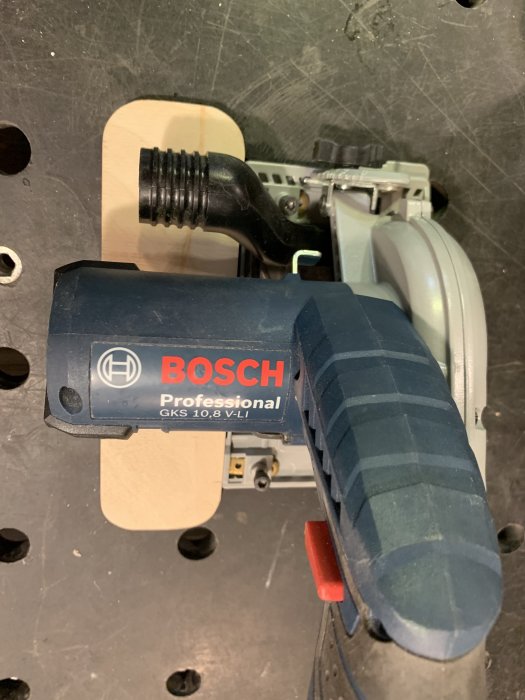 Bosch professionell batteridriven cirkelsåg monterad på hemgjord kapjigg av masonit.