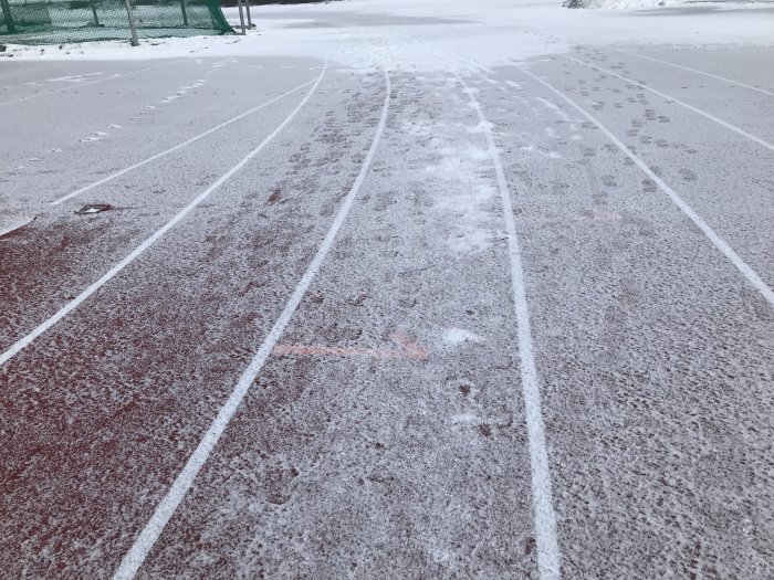 Löparbanor täckta med ett tunt lager snö och fotspår som syns tydligt.
