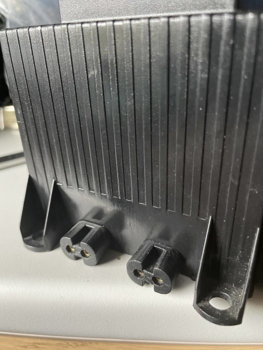 En 24V transformator med två svarta kontakter som har stiften synliga.