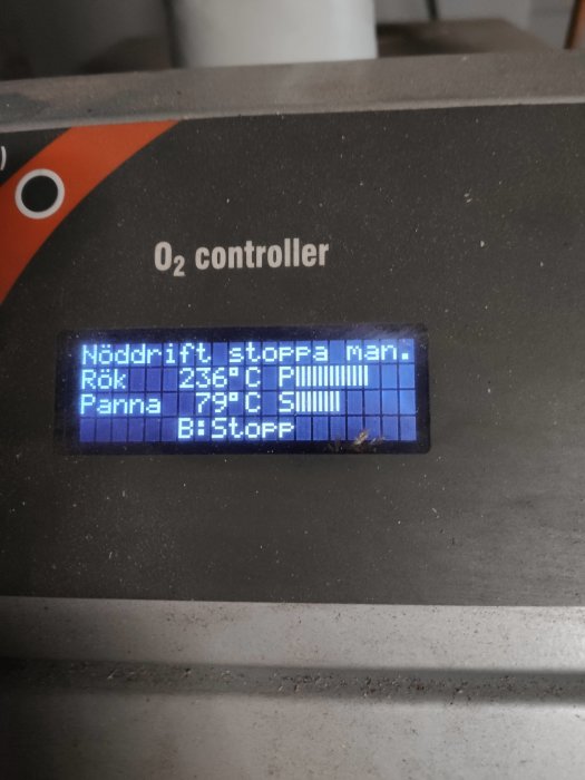 LCD-display på en pannstyrningsenhet som visar olika driftstatusar och temperaturer.