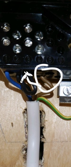 Elektrisk kabelanslutning med markerad brun tråd som ska bytas till svart i en anslutningsdosa.