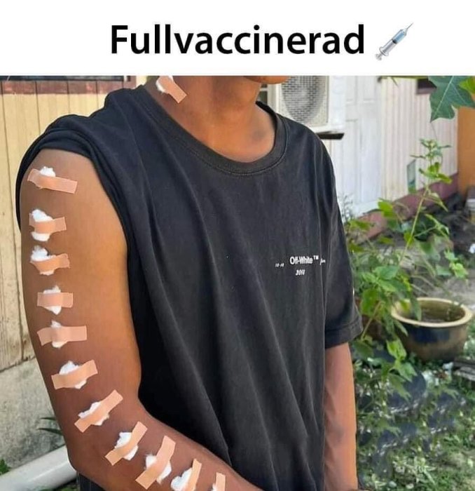 Person med plåster i rader på armen och texten "Fullvaccinerad" överst, samt en spruta-emoji.