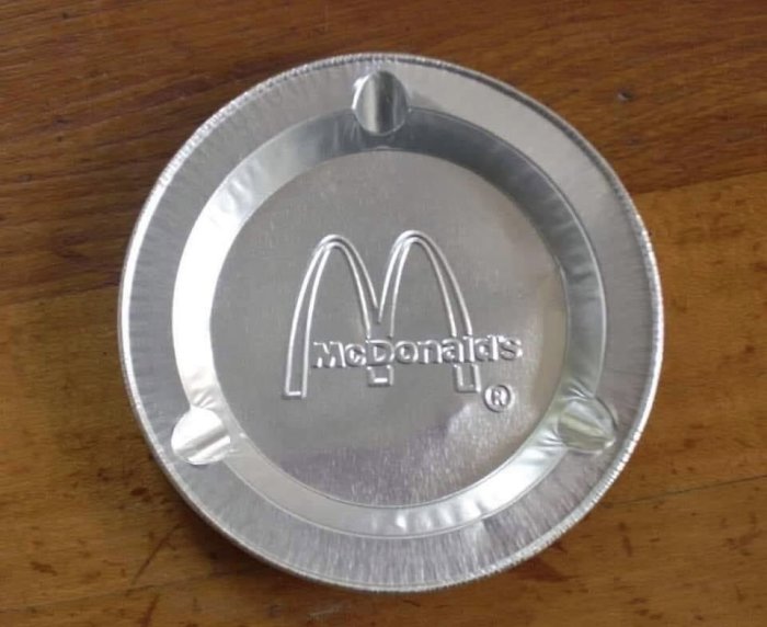 Aluminiumlock med präglat McDonald's-logotyp på träyta.