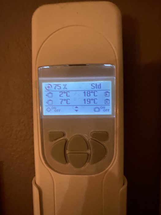 Digital termostat visar temperaturändring från 18°C till 19°C, antyder uppvärmning inomhus.