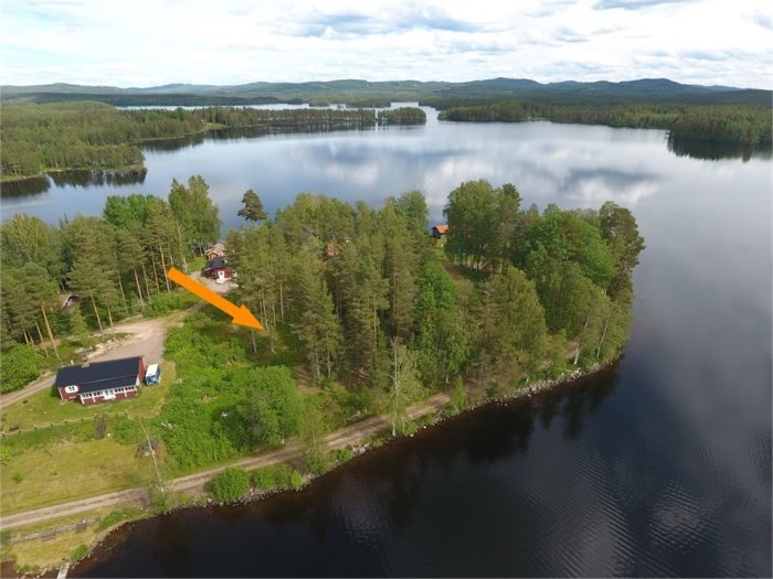 Flygbild över skogstäckt udde vid Kättbosjön med markerad tomt för fritidshus i Dalarna.