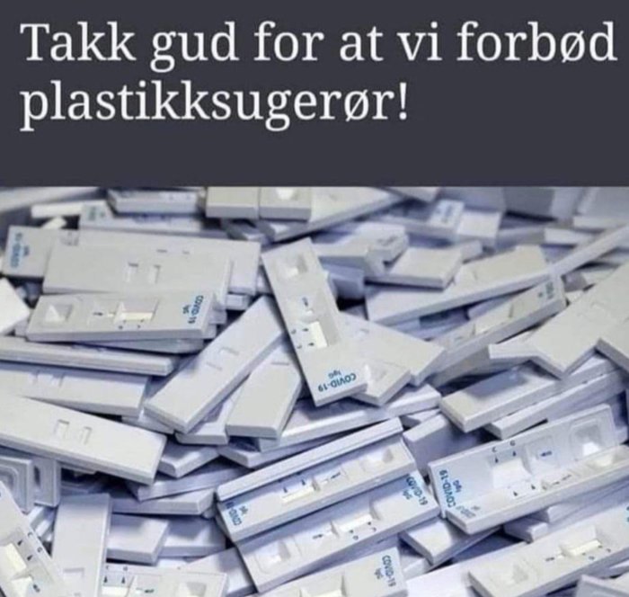 Hög av begagnade snabbtester för Covid-19 med texten "Tack gud för att vi förbjöd plastiksugrör!" på norska.
