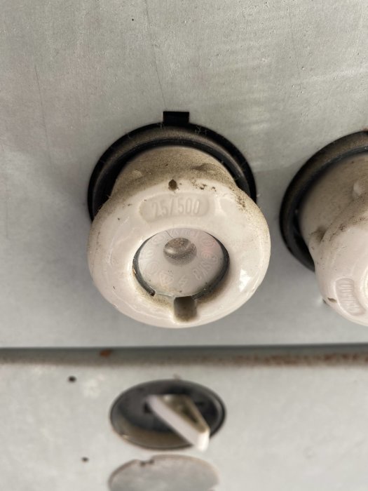 Närbild av en gammal säkring med texten "25/500" i en elektrisk central.