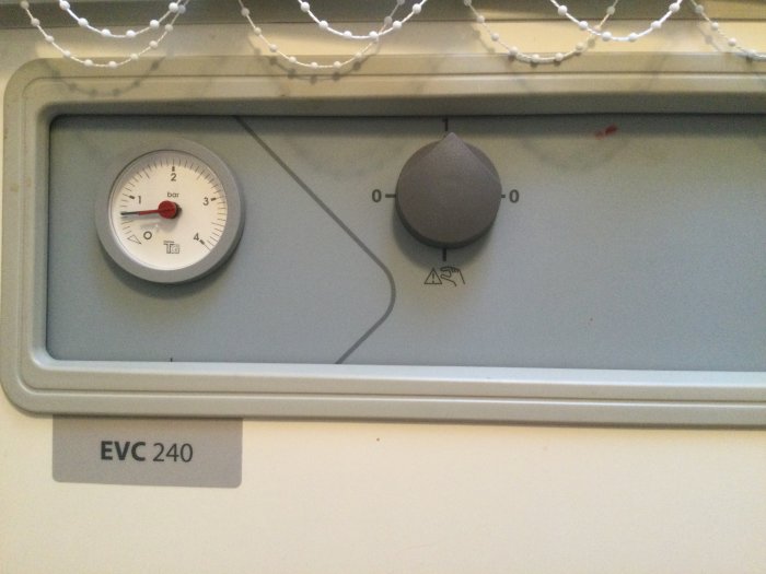 Nibe EVC 240 elpanna med termostatknopp och tryckmätare som visar under 1 bar tryck.